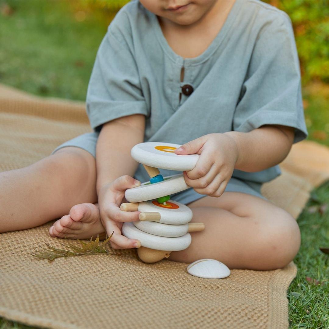 A boy threading the lacing sheep on a jute rug