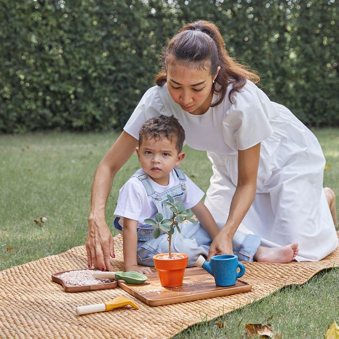 A parent and child planting together in the garden